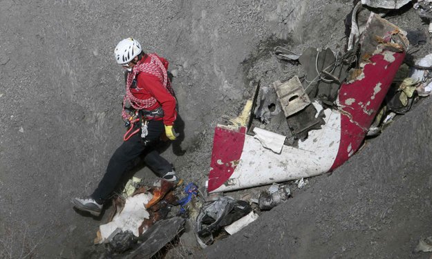 A French rescue worker inspects the remains of the Germanwings Airbus A320 at the site of the crash