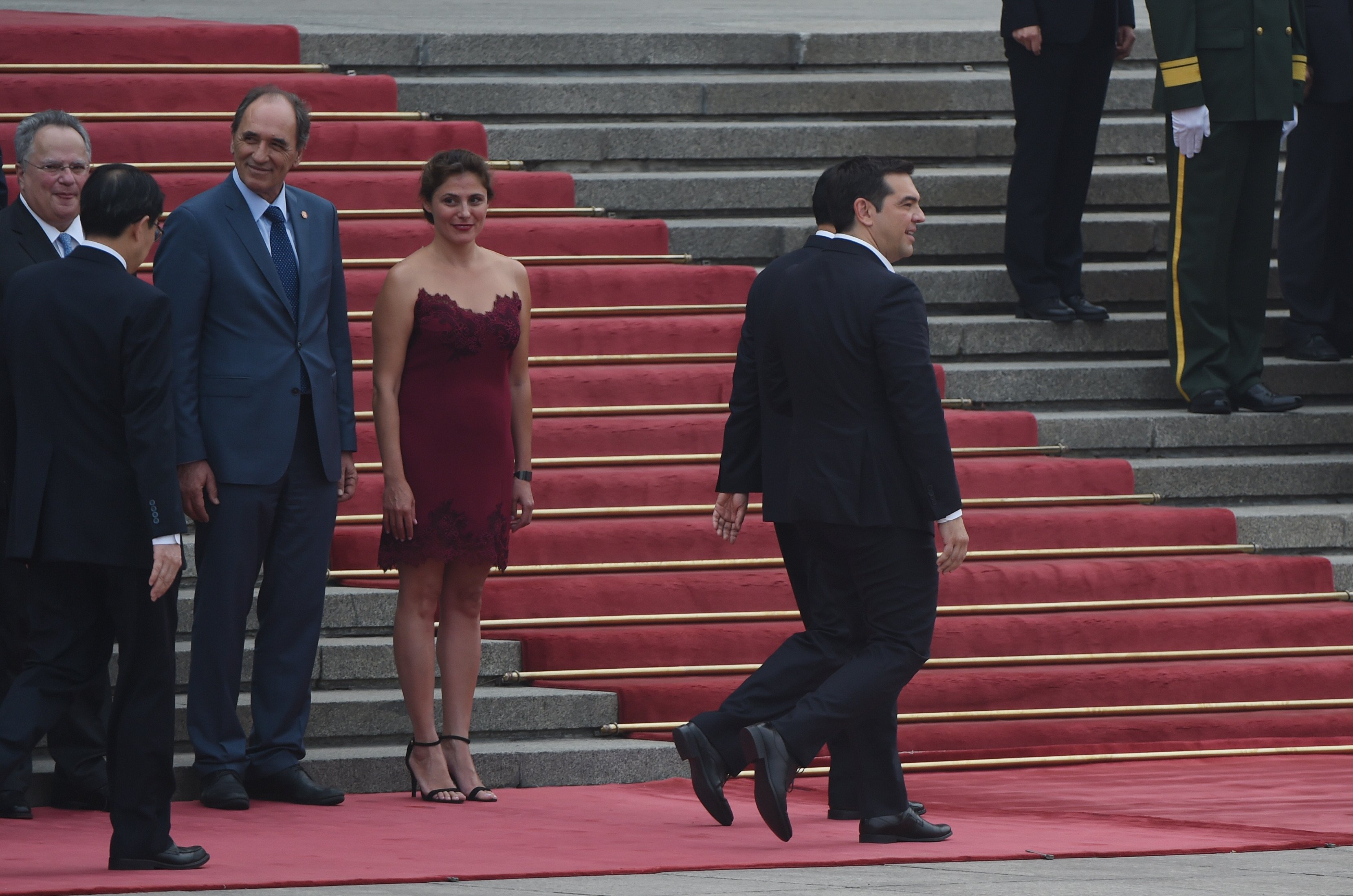Greek Prime Minister Alexis Tsipras (R) walks with Chinese Premier Li Keqiang (obscured) as Tsipras' partner Betty Batziana (4th L) looks on during a welcome ceremony outside the Great Hall of the People in Beijing on July 4, 2016.  Tsipras is on a state visit to China. / AFP / GREG BAKER        (Photo credit should read GREG BAKER/AFP/Getty Images)