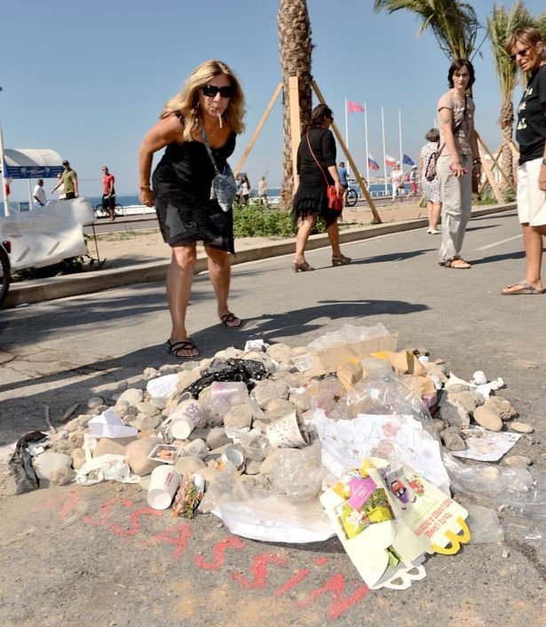 a-passer-by-spits-on-a-pile-of-rubbish-dedicated-to-the-nice-terror-killer