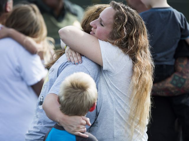 Korrie Bennett hugs Heather Bailey after recovering their children following a shooting at Townville Elementary in Townville Wednesday, Sept. 28, 2016. A teenager killed his father at his home Wednesday before going to the nearby elementary school and opening fire with a handgun, wounding two students and a teacher, authorities said. (Katie McLean/The Independent-Mail via AP)