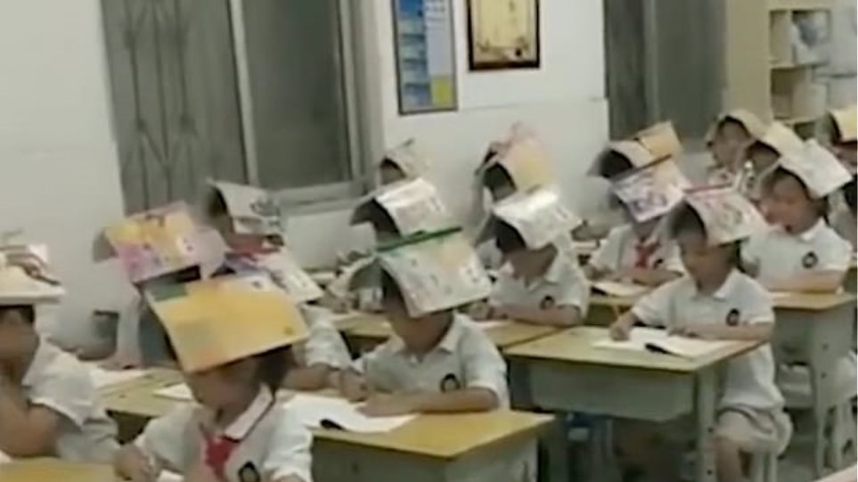 Κίνα: Δάσκαλος φόρεσε "καπέλο" τα βιβλία στους μαθητές του για να μην... καμπουριάζουν!(Photo /Video)